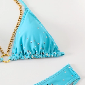 Close-up of light blue bikini with white dots and elegant gold chain straps