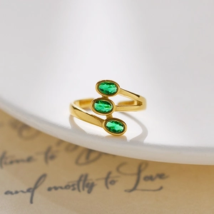 Detail of 18K gold-plated stainless steel ring with three green oval zircons