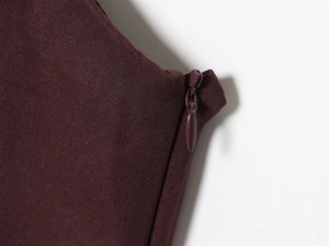Makrodetail eines hochwertigen verdeckten Reißverschlusses an einem weinroten Kleid