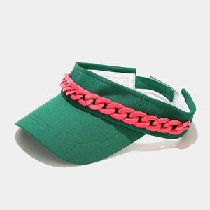 Détail de la visière en coton vert et chaîne rose avec étiquette d'entretien