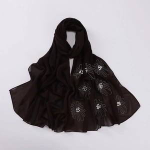 Detail of brown chiffon hijab with silver rhinestones and white pearl flower patterns