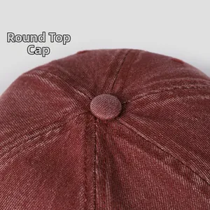 Détail de la calotte arrondie et des coutures sur une casquette en denim rouge délavé