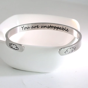 Polished C-shaped stainless steel cuff bracelet with You Are Unstoppable engraving
