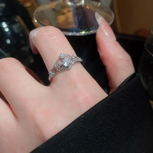 Macro shot of a silver crown-shaped ring with sparkling cubic zirconia on a finger