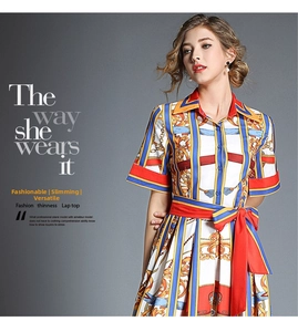 Detail of baroque print dress featuring blue stripes and a vibrant red satin waist tie