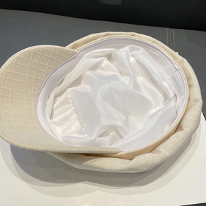 Detailed view of striped baker boy cap showing white satin lining and fine fabric texture