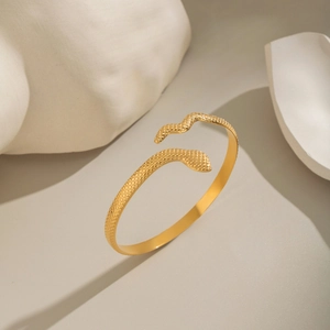 Macro detail of golden snake bangle showing intricate scale texture and craftsmanship