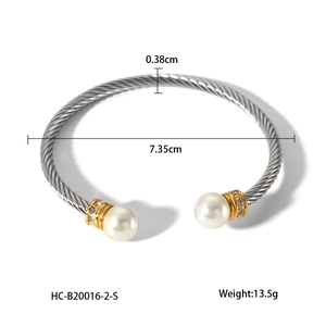 Detail of silver cable bangle featuring 0.38cm width, white pearls and gold accents