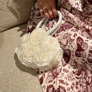 Detail of handmade white satin rose handbag with floral texture for elegant styling