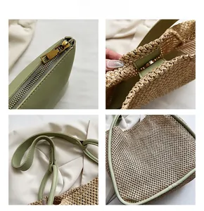 Detail view of woven straw tote with green faux leather trim and golden metal zipper