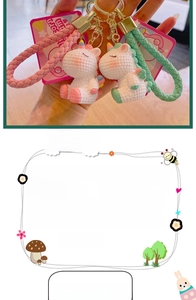Detail view of unicorn keychain sets in pink and green PVC with braided wrist straps