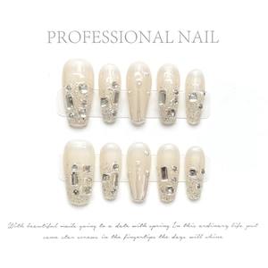 Detail of handcrafted long coffin fake nails with nude gradient and silver glitter diamonds