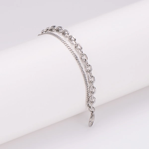 Bracelet double chaîne hip-hop argenté au design moderne sur un présentoir de bijoux blanc