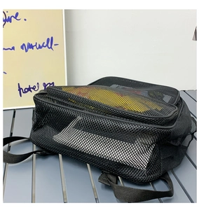 Detail of black mesh backpack featuring multi-layer zippers and breathable material