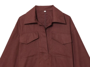 Detail of reddish-brown shirt collar and chest pockets with size S label on fabric