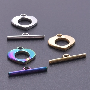 Macro view of heart-shaped stainless steel toggle clasps in silver, gold, and rainbow finish