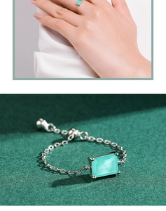 Detail of silver chain bracelet featuring a rectangular turquoise stone and adjustable link