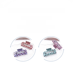 Détail des pinces à cheveux papillon colorées avec motifs d'ailes noires fins