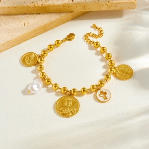 Gold plated beaded bracelet with baroque pearl, cross, and religious coin charms on stone