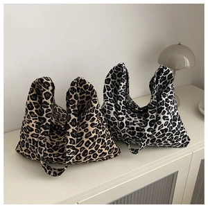 Detail view of large leopard print canvas tote bags in brown and black-white tones