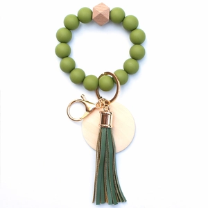 Detail of green silicone beads and leather tassel on a wooden bead keychain ring
