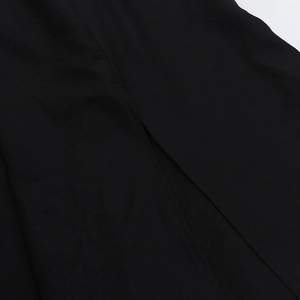 Gros plan détaillé sur la texture du tissu noir et les finitions de la fente latérale