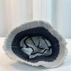 Close-up of denim bucket hat interior with adjustable drawstring and frayed edges