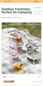 Outdoor picnic scene with transparent portable food storage containers on grass