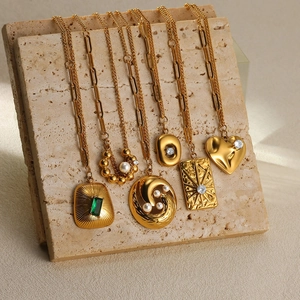 Macro shot of 18K gold-plated stainless steel pendants with emeralds and pearls