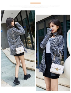 Detail of white chain crossbody bag with red carriage print on female model outfit