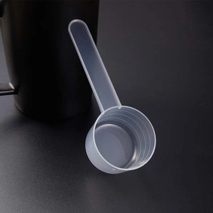Macro shot of a transparent plastic measuring spoon with precise scale lines for baking