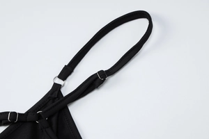 Dettaglio spalline nere regolabili con anelli di metallo argento e trama a maglia