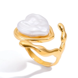 Bague vintage dorée style lave avec grande perle en forme de cœur sur fond blanc