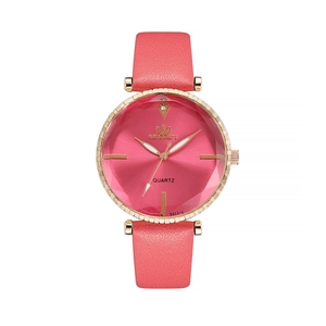 Detail of rose gold watch with faceted glass and pink leather strap showing dial texture