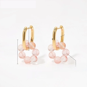 Macro view of gold U-shaped earrings with natural pink stone beaded charms 20.4mm size