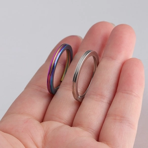Close-up of rainbow and silver stainless steel flat key rings held in hand