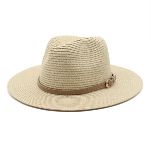 Close-up of classic straw Panama hat with brown leather band and golden buckle detail