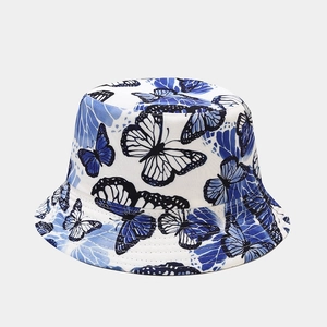 Detail shot of the blue butterfly print on white cotton fabric of the sun bucket hat