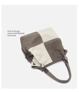 Close-up of canvas tote bag showing brown patchwork, fabric texture, and metal ring accents
