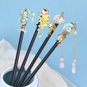 Vintage wooden hairpins with elegant floral tassels and pearls on blue background
