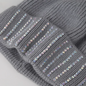 Detail of grey knitted beanie with sparkling rhinestones and thick ribbed texture