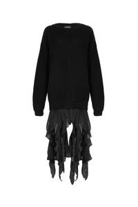 Detail of black knit sweater featuring layered ruffle chiffon hem and intricate textures