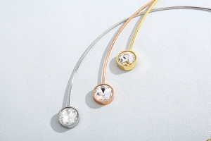 Detail of stainless steel neck collars with large cubic zirconia in silver, rose gold and gold