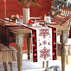 Christmas table runner with red plaid edge, snowflakes and elk on a festive table