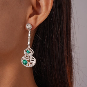 Gros plan de boucles d'oreilles gourde argentées avec cristaux portées par un mannequin