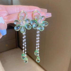 Detail of green floral earrings with sparkling rhinestones and long pearl tassels