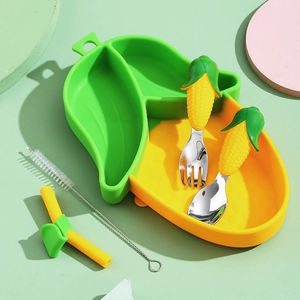 Silicone avocado baby plate with corn-shaped fork and spoon set on green background