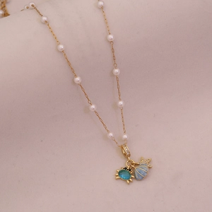Detailed shot of ocean-themed necklace with blue crab, shell, and starfish charms