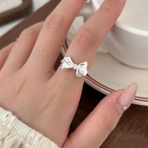 Polished S925 sterling silver bow ring displayed on a finger for a sweet fashion look