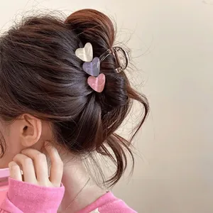 Detail of three-color heart hair claw clip holding hair in a stylish updo hairstyle
